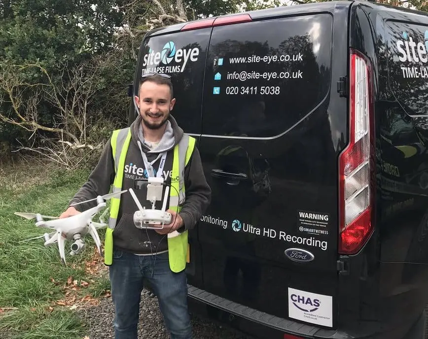 drone filming Site Eye drone pilot holding a camera drone beside a Site Eye van