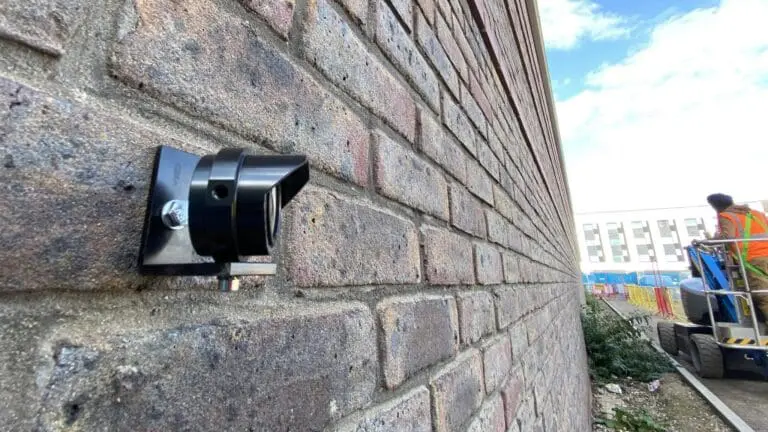 Structural monitoring prism fixed to a brick wall