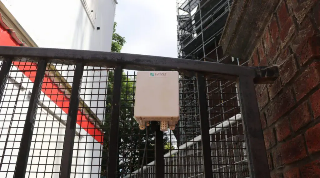 Survey Solutions noise, dust and vibration monitor on the gates of a demolition site